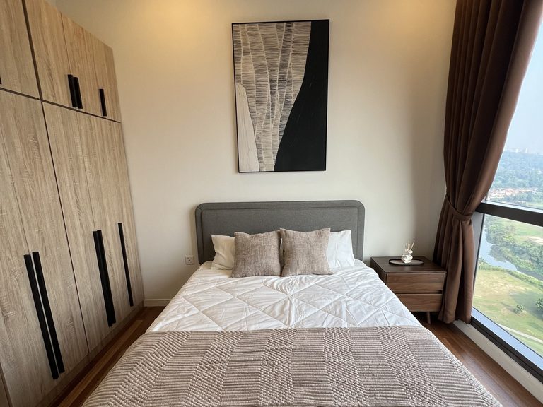 Master bedroom showing the light-oak three-door wardrobe beside the bed and a bedside table