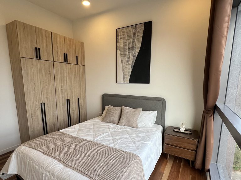 Master bedroom from the doorway, showing the wardrobe, framed artwork, bed and window